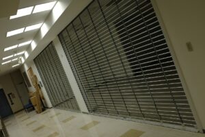 Porta de enrolar vazada com grade retangular em espaço comercial interno